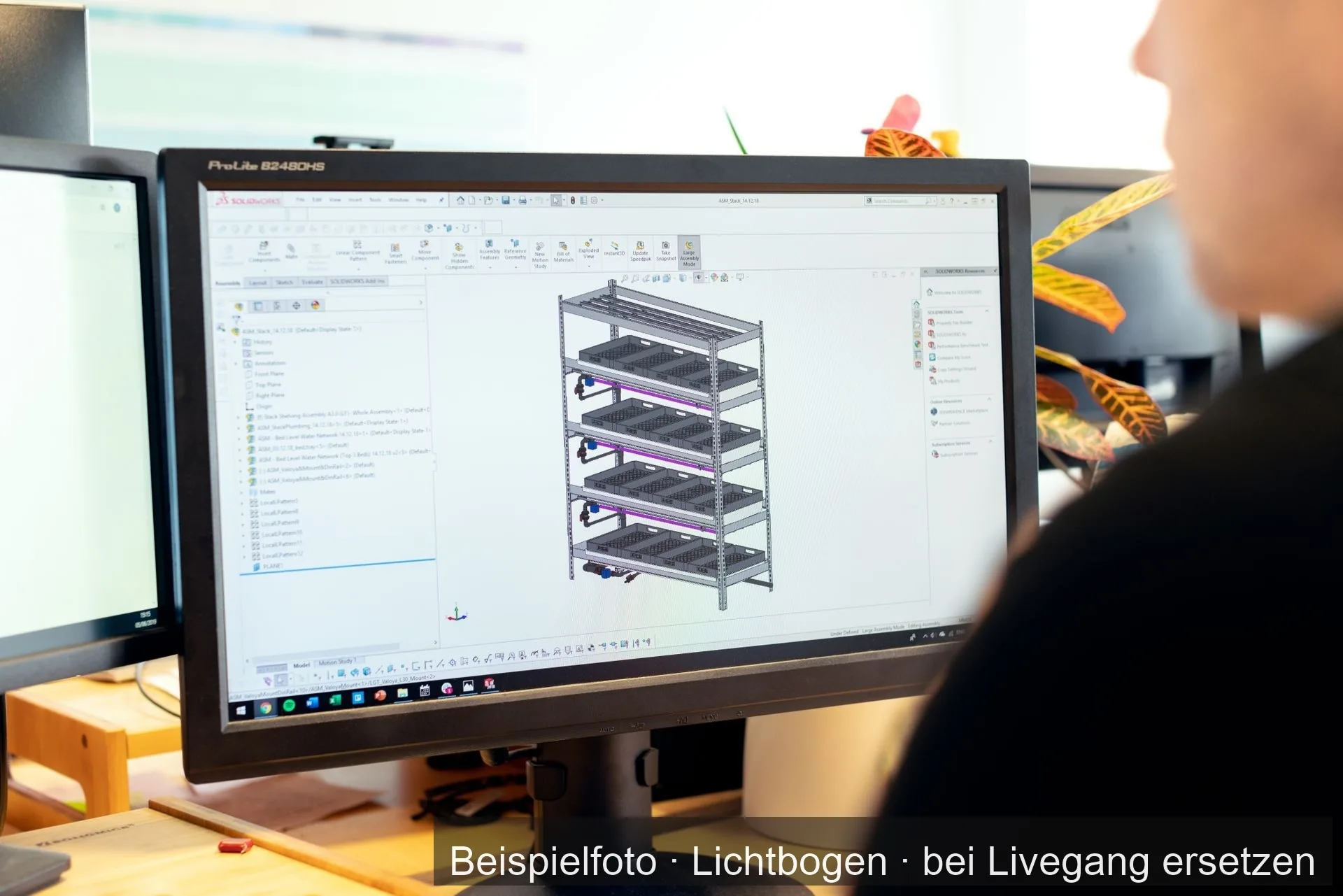 Ein Konstrukteur arbeitet am Bildschirm an einem 3D-Modell eines Regalgestells.