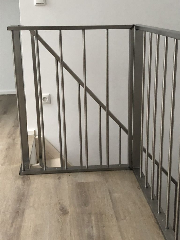 Graues Stabgeländer aus Metall am Treppenauge.