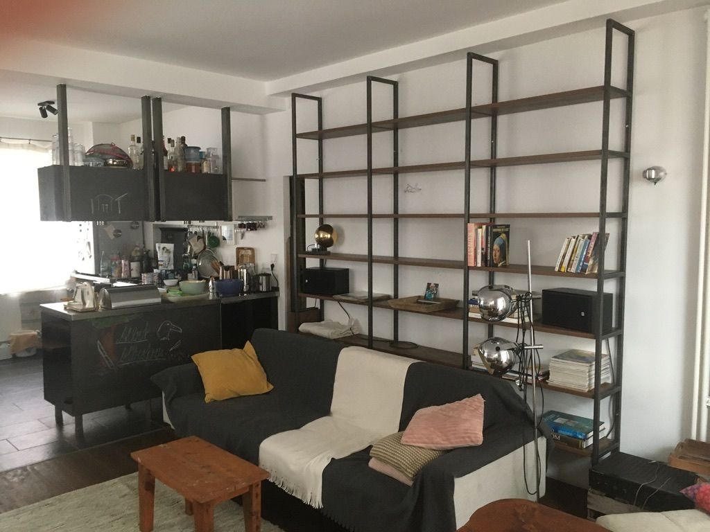Deckenhohes Wandregal aus Metall in einem Wohnzimmer.