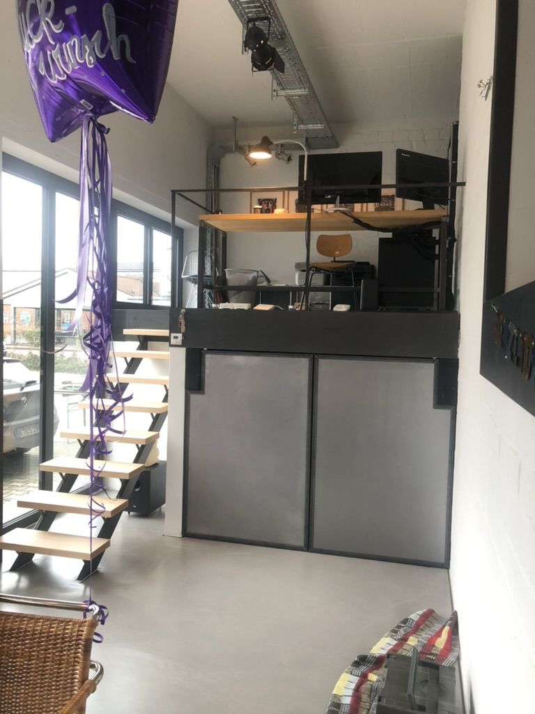 Hochebene aus Stahl mit Brüstung und Treppe in einem Büro, darunter Türen aus Stahlblech.
